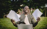 Student with documents and laptop happy about getting into university
